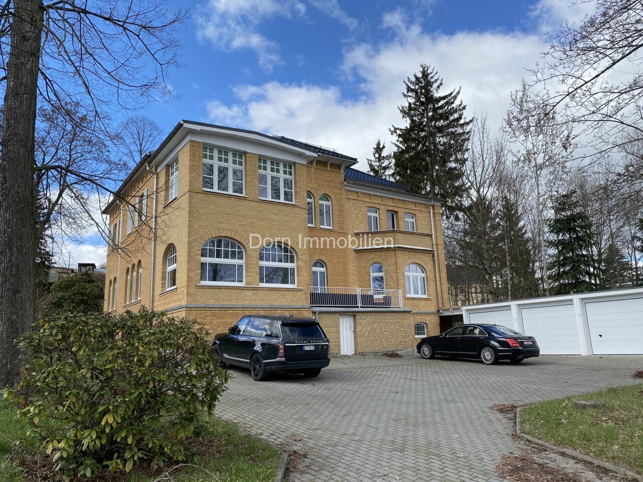 Hausansicht mit Stellplätzen und Garagen Hausansicht mit Stellplätzen und Garagen