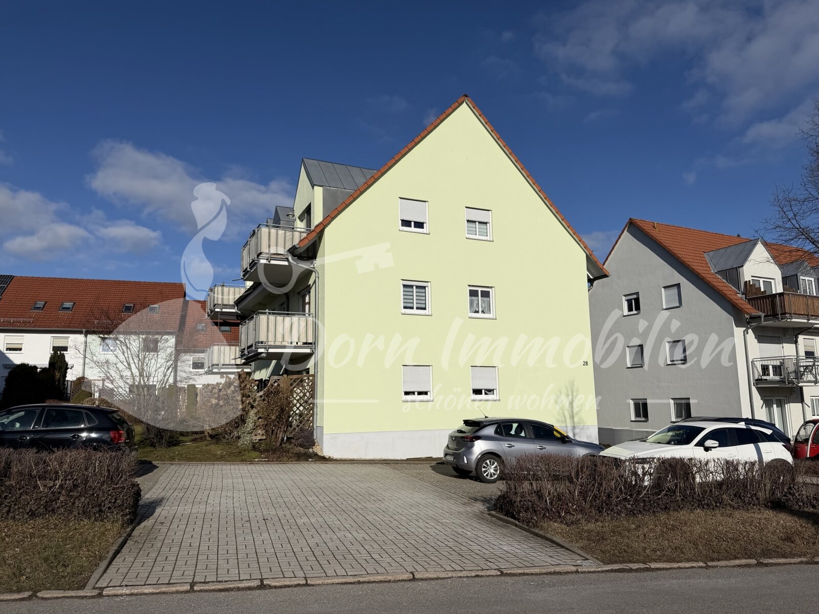 Hausansicht mit Parkplätzen